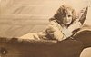 Image 1 - girl lying on couch, back of couch to front, facing right looking front, right hand on pillow
