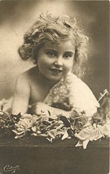 girl with blond hair is in front of bunch of roses on table