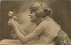 Image 1 - woman with fluffy hair leaning over table looking at roses held between both hands