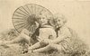 Image 1 - two boys play in straw, looking forward, parasol behind, handle to left of boy on left