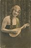 Image 1 - pretty girl with long hair in off shoulder dress faces partly right with mandolin held in before her, looks front, braid over her right shoulder