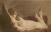 Image 1 - girl lying on couch holding pillow, facing left, looking front, feet up in air