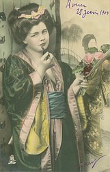 young woman in Japanese dress faces front smoking cigarette using long holder, head tilted to her right shoulder