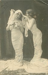 girl on right adjusts shawl on the head & shoulders of her partner