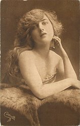 pretty girl poses, both elbows on fur, left hand to left side of face, right hand down on fur