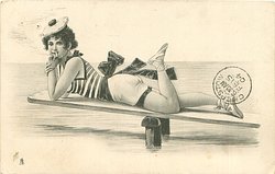 girl lying prone on diving board, her left foot up in air, fingers to mouth