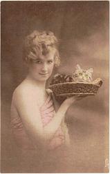 girl faces right looking front holds kitten up in basket