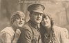 Image 3 - soldier between two girls, hat on soldier, all three face forward, left girl has hand on soldier's shoulder