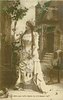 Image 1 - JE CROIS QUE CETTE CHAINE NE M'IRAIL PAS MAL! Marguerite stands in front of chateaux, touching her long chain necklace