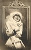 Image 1 - pretty girl with ermine fur & cap posed in front of framed mirror, she faces front looks up, both hands hold fur in front of her