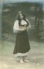Image 1 - Mignon stands playing mandolin, looking down