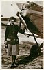 Image 1 - in skirt, holding onto blade of prop, right arm at side