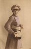 Image 1 - uniformed postlady delivering letters, faces right, looks forward, opens satchel with her left hand, letters in her right