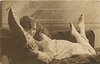 Image 1 - girl lying on couch holding pillow, facing left, looking front, feet up in air