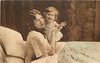 Image 1 - mother in bed with child, mother left, her right hand holds childsoutstretched left arm, child standing close to mothers left cheek