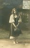 Image 1 - Mignon stands holding bag, looking down