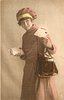 Image 1 - uniformed postlady delivering letters, faces left, looks forward, holds letter in left hand, stack of letters in her right hand
