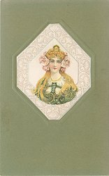 head & shoulders study of golden haired brunette in green dress looking & facing front