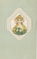head & shoulders study of golden haired brunette in green dress looking & facing front