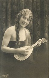 pretty girl with long hair in off shoulder dress faces partly right with mandolin held in before her, looks front, braid over her right shoulder
