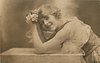 Image 1 - woman with fluffy hair leaning over table looking at roses held between both hands