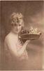 Image 1 - girl faces right looking front holds kitten up in basket