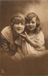 mother & daughter, head & shoulders, they look front, daughter lightly touches mother's chin