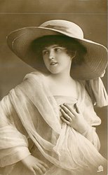 girl in panama hat, dress & filmy shawl faces partly right but looks over right shoulder to left of card
