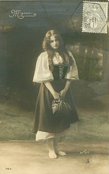 Mignon stands holding bag, looking down