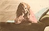 Image 2 - girl lying on couch,looking front, both hands under her chin