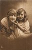 Image 1 - mother & daughter, head & shoulders, they look front, daughter lightly touches mother's chin
