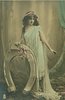 Image 1 - she stands erect by fantasy horseshoe holding it & flowers with her right hand