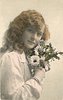 Image 1 - girl right profile, holds flowers to left cheek, looks at camera