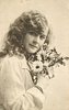 Image 1 - girl right profile, holds flowers to left cheek, looks at camera